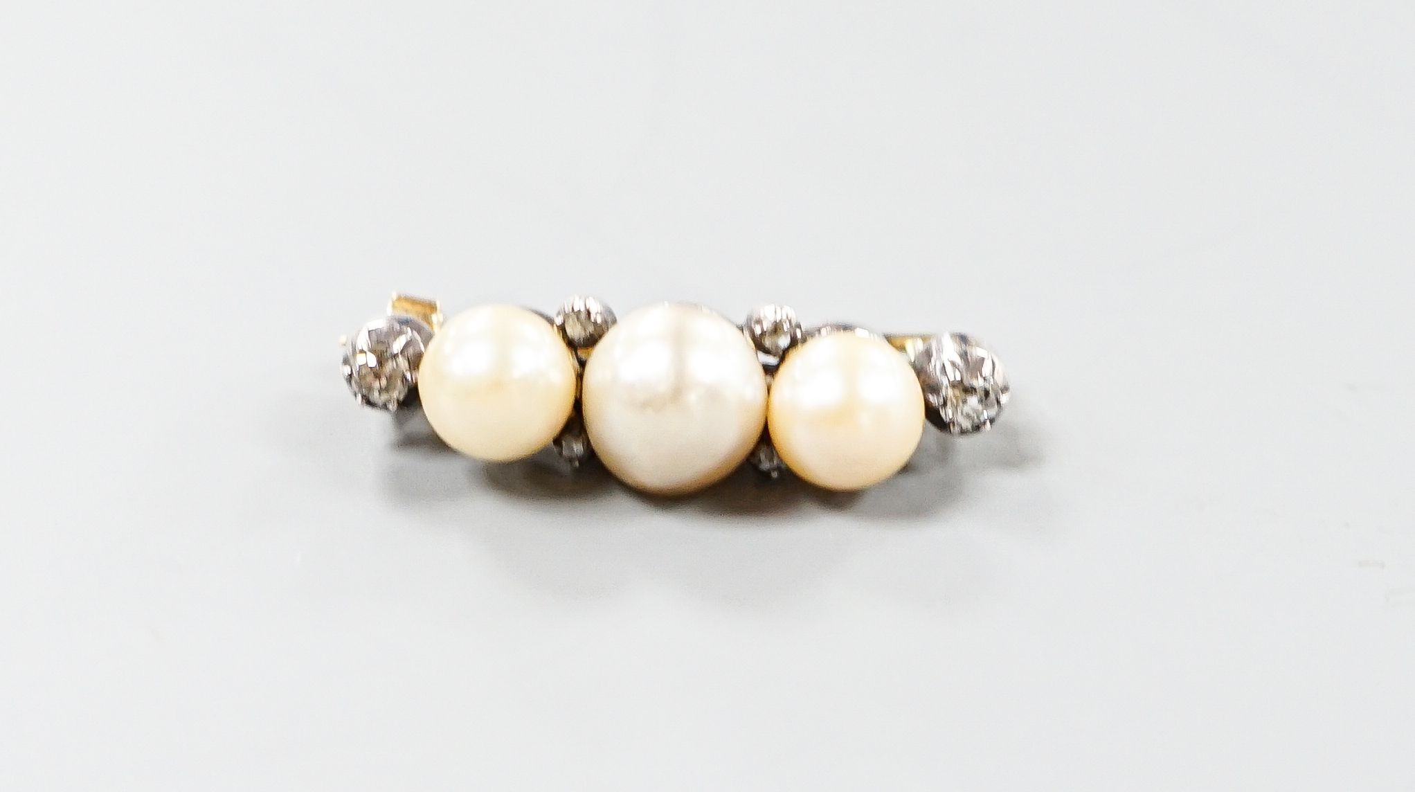 A yellow metal, three stone cultured pearl and six stone diamond brooch, 34mm, gross weight 8.1 grams.